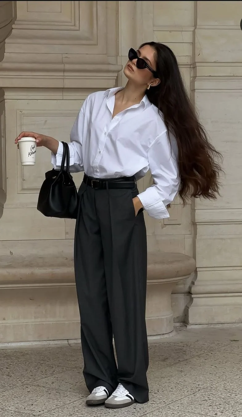 City girl commuter outfit with oversized white shirt dark grey wide leg pants and sneakers