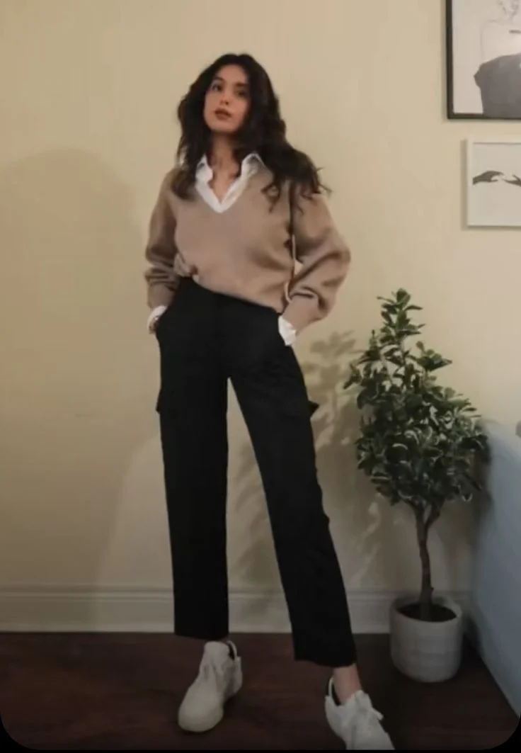 Smart casual Friday outfit with brown V neck sweater layered over white shirt and black pants