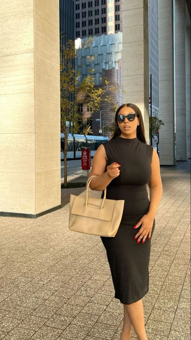 Black sleeveless dress + beige bag